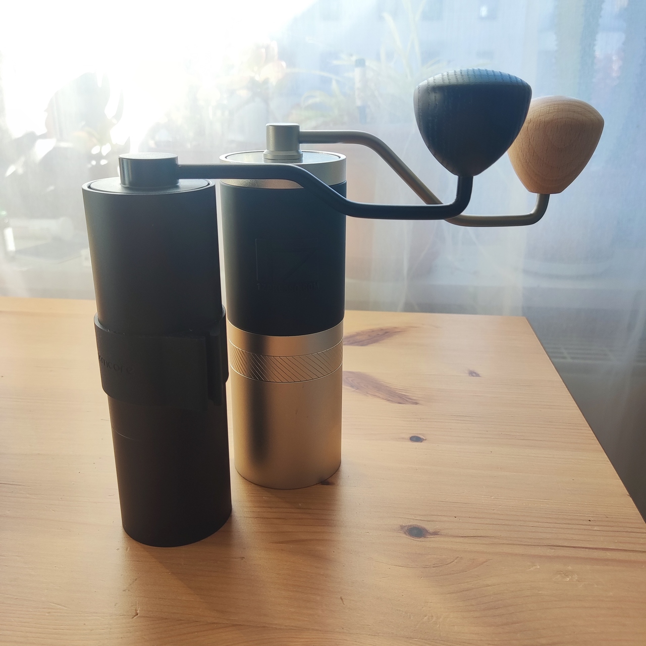 Photo of two hand grinders, a Normcore V2 (38mm) and a 1ZPresso JX